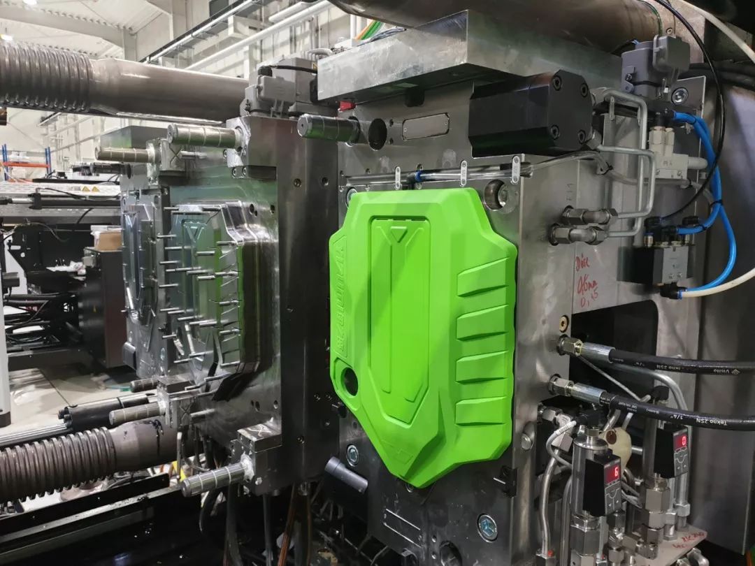 Overmolding tool open on an injection molding machine with a production part in the cavity